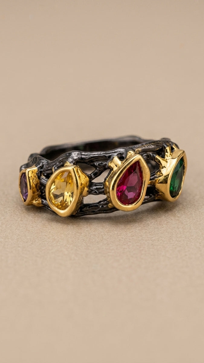 Ring with gold band and multicolored gemstones on a beige background