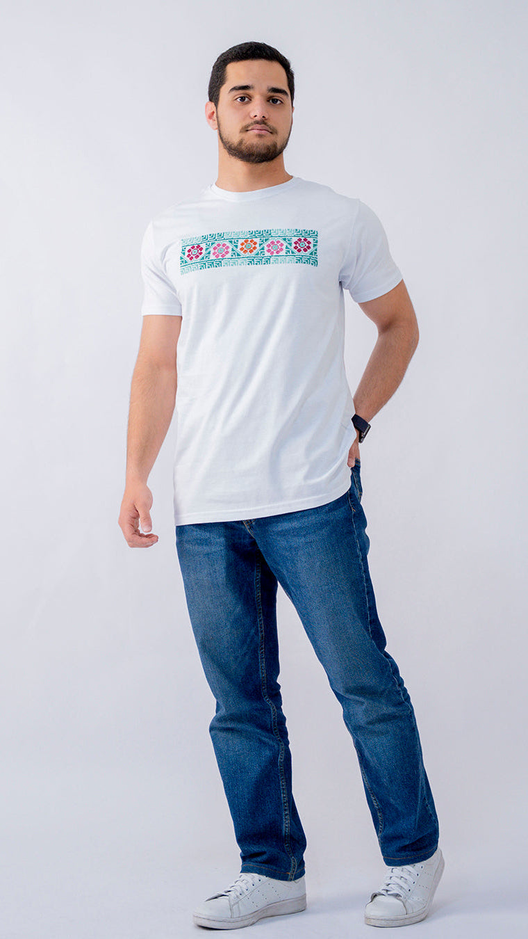 Man wearing a white t-shirt with a colorful design and blue jeans on a white background