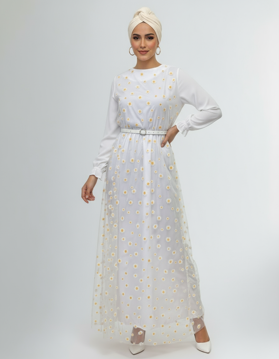 Woman wearing a white dress with yellow floral pattern on a plain background