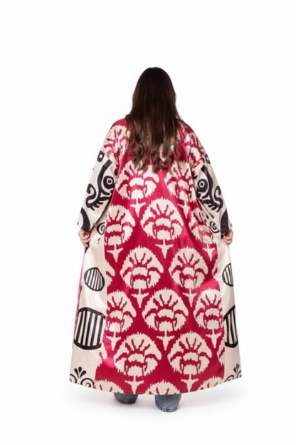 Person wearing a long, patterned dress with a red and white design on a white background