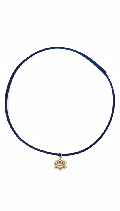 Navy blue choker necklace with a gold crown pendant on a white background