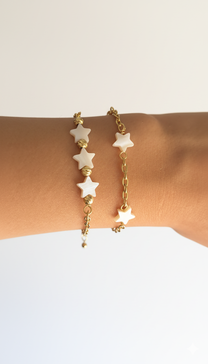 Gold bracelet with star-shaped beads on a wrist against a white background
