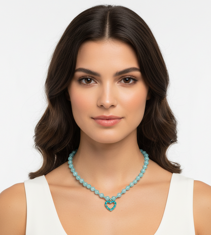 Woman wearing a turquoise necklace with a heart pendant on a white background