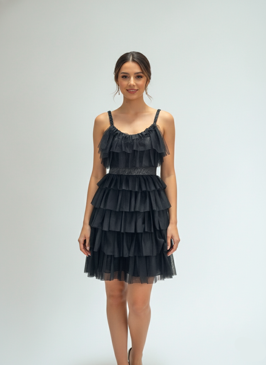 Woman wearing a black tiered dress on a white background
