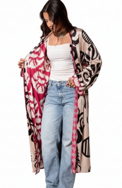 Woman wearing a patterned cardigan over a white top and jeans on a white background