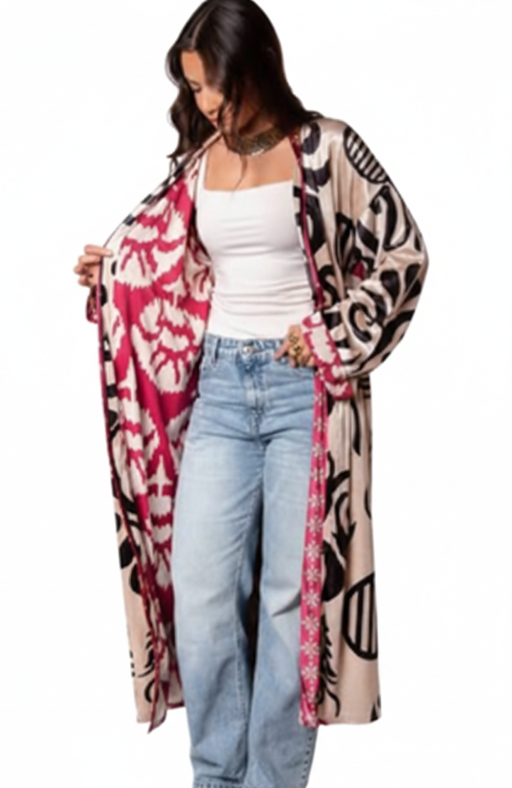 Woman wearing a patterned cardigan over a white top and jeans on a white background