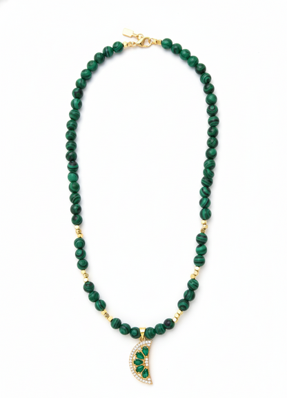 Green beaded necklace with a gold pendant on a white background