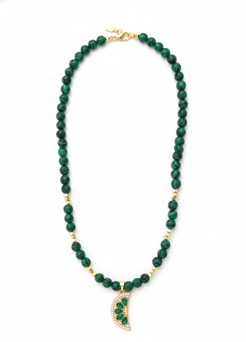 Green beaded necklace with a gold pendant on a white background