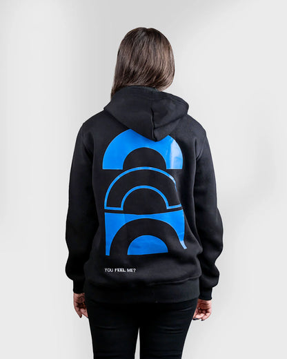 Person wearing a black hoodie with a blue graphic on the back against a white background