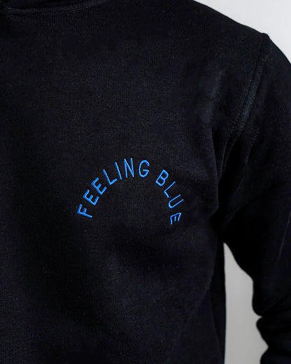 Black long-sleeve shirt with 'FEELING BLUE' text on a plain background