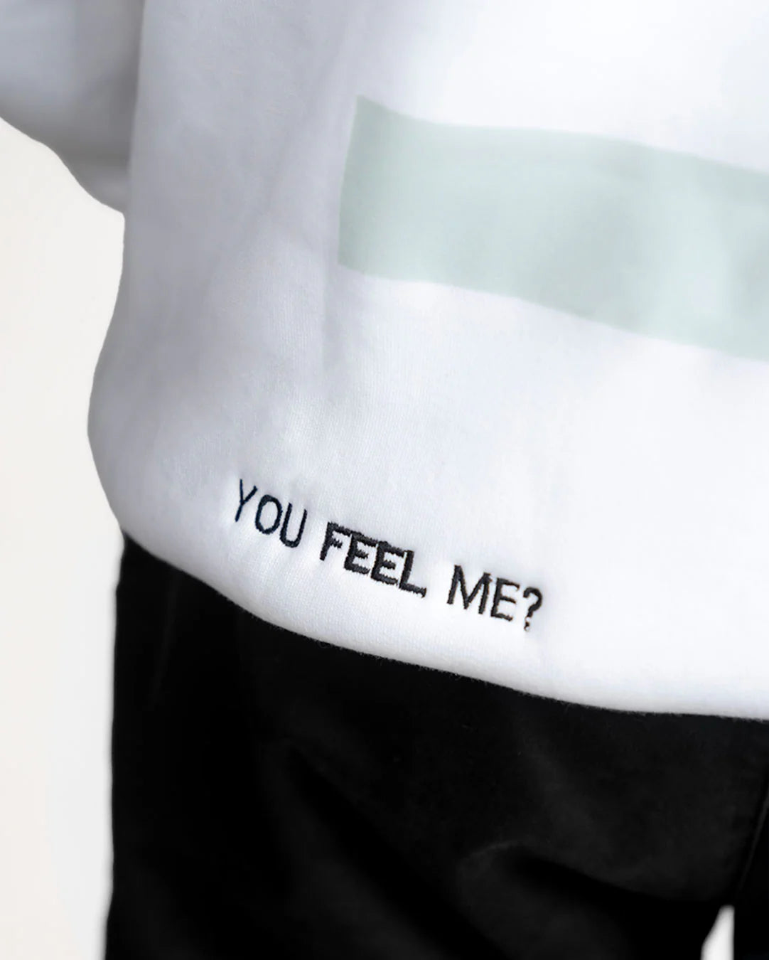 Text 'YOU FEEL ME?' on a white shirt with a black waistband.