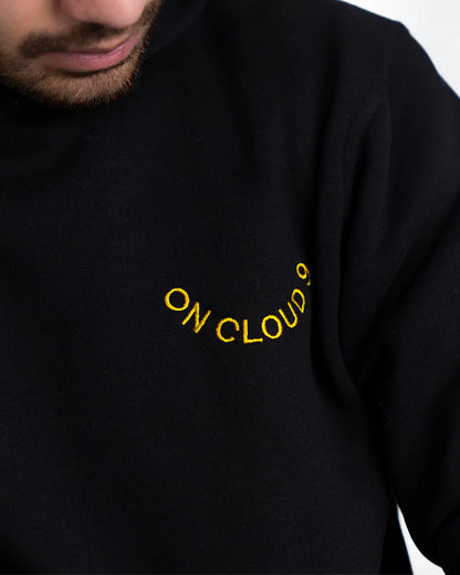 Black sweatshirt with 'ON CLOUD' text in yellow on a plain background