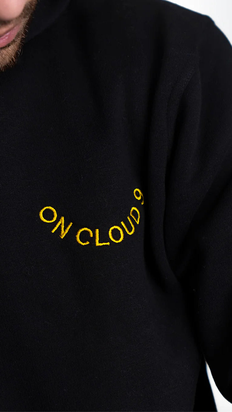 Black sweatshirt with 'ON CLOUD' text in yellow on a plain background