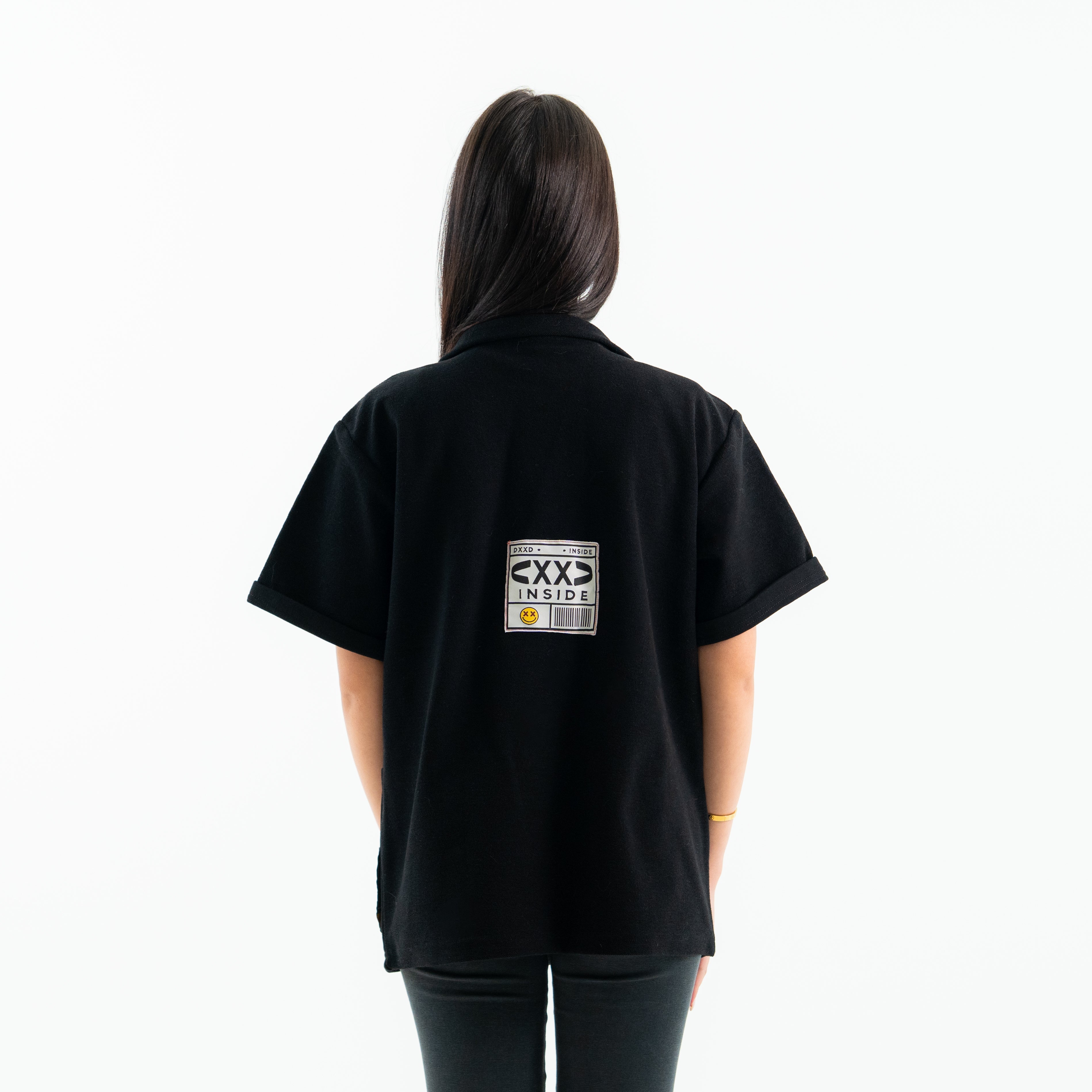 Person wearing a black t-shirt with a graphic on the back against a white background