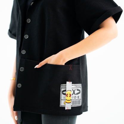 Person wearing a black apron with a cartoon character and text on a white background