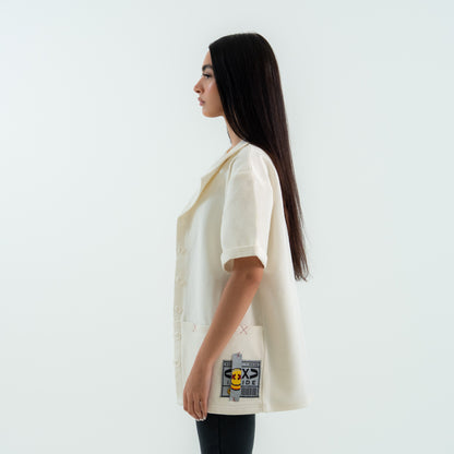 Woman wearing a cream-colored jacket with a brand logo on a white background