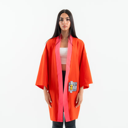 Woman wearing a bright orange kimono-style robe with a patch on a white background