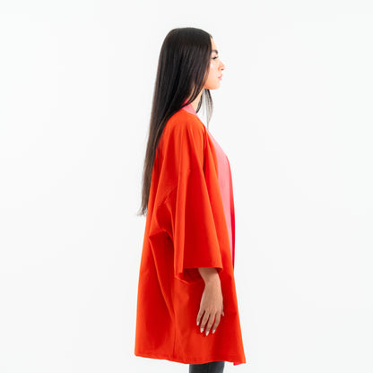 Woman wearing an orange kimono-style garment on a white background