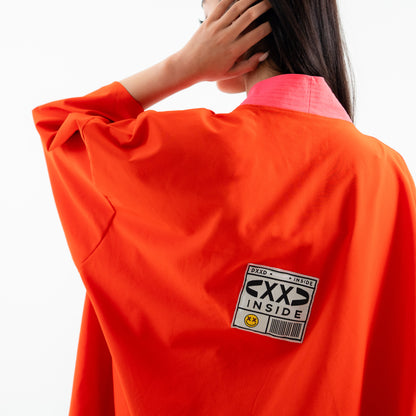 Person wearing an orange jacket with a 'CXS INSIDE' label on a white background