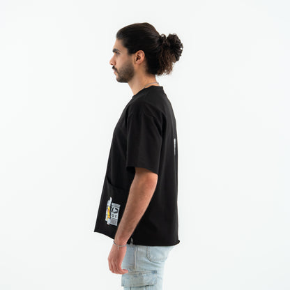 Man wearing a black t-shirt with a small graphic on the chest against a white background