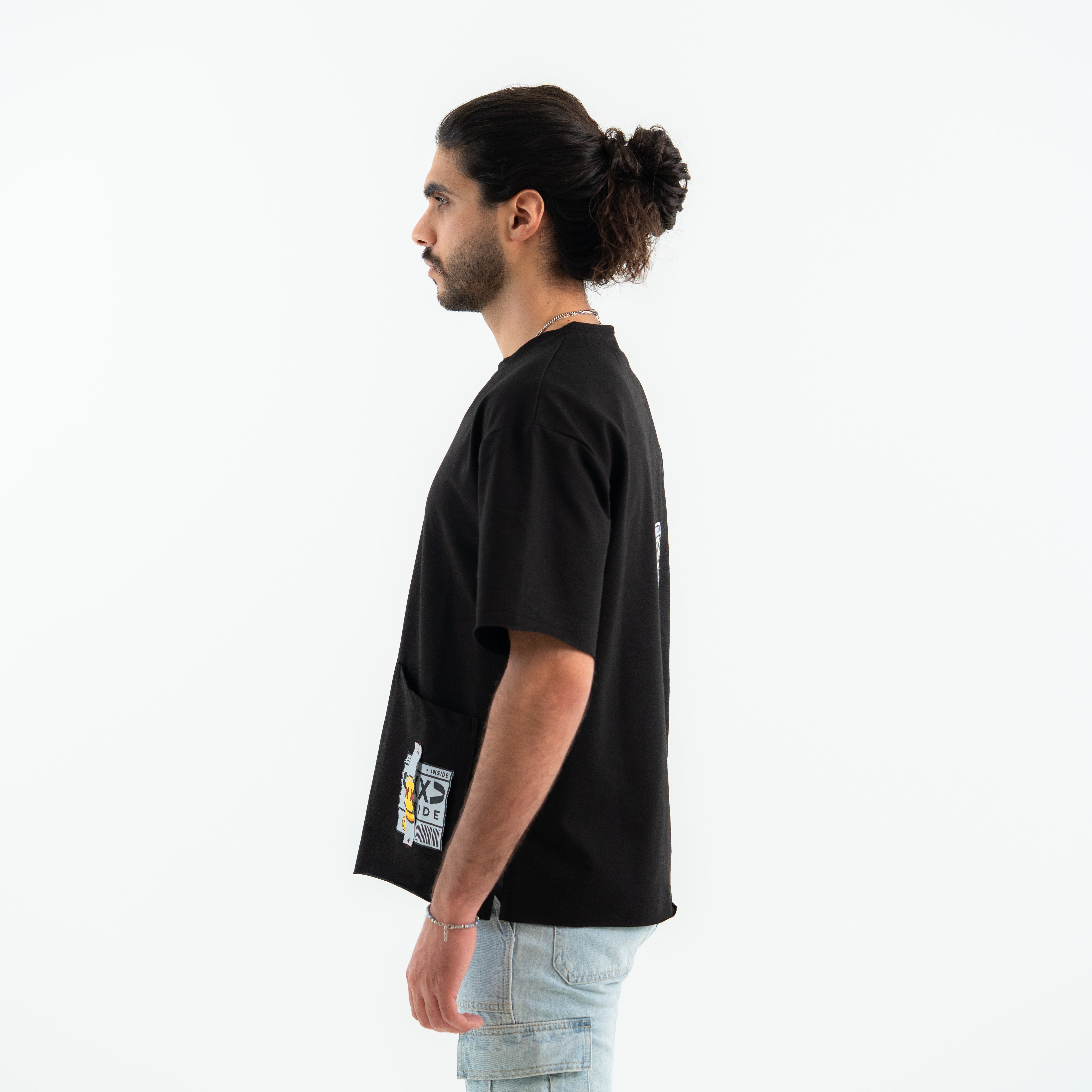 Man wearing a black t-shirt with a small graphic on the chest against a white background