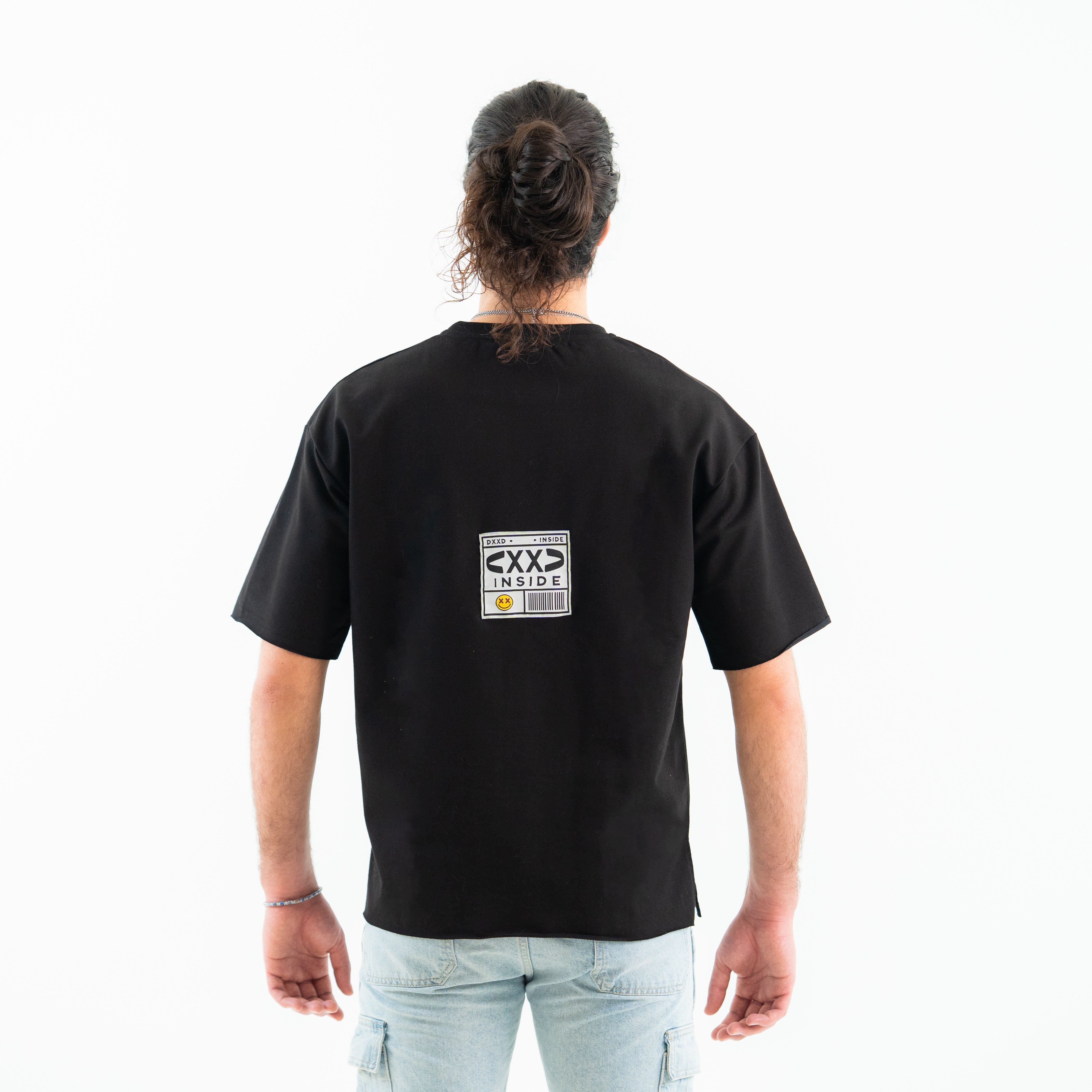 Person wearing a black t-shirt with a graphic on the back against a white background