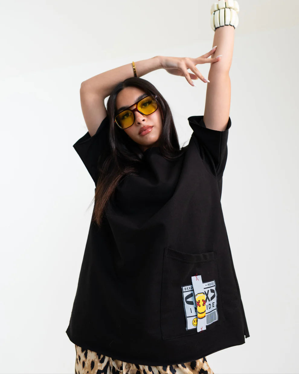 Person wearing a black oversized shirt with a graphic design on a white background