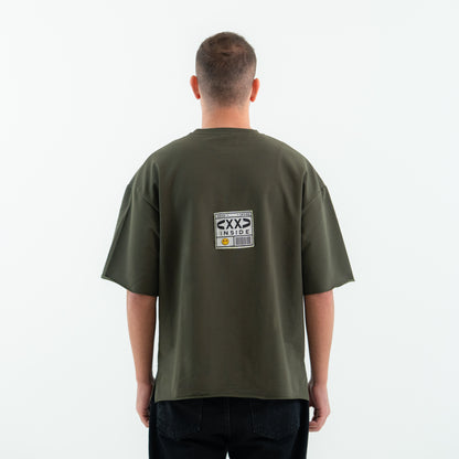 Person wearing a green t-shirt with a graphic on the back against a white background