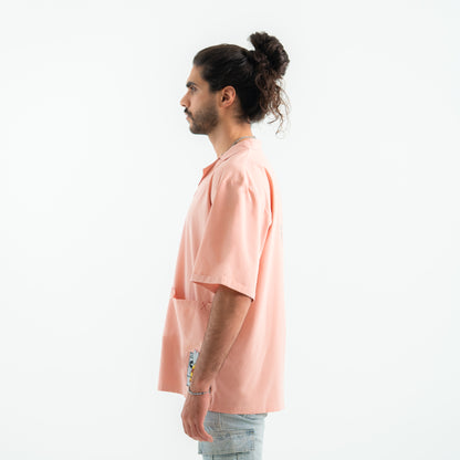 Man wearing a peach-colored t-shirt with a white background