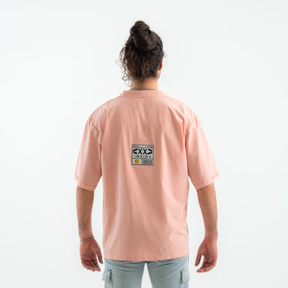 Person wearing a pink t-shirt with a graphic on the back against a white background