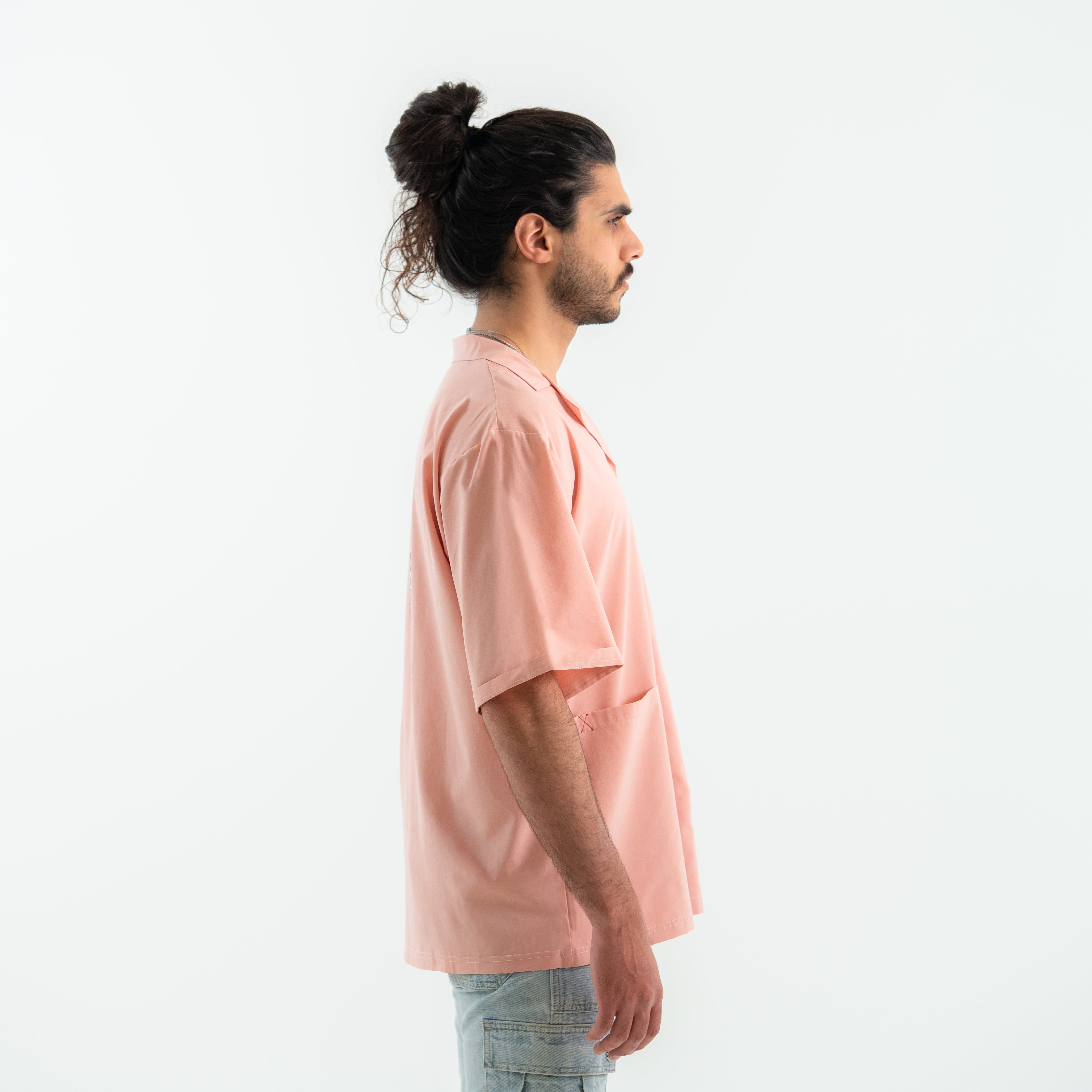 Man wearing a light pink shirt on a white background