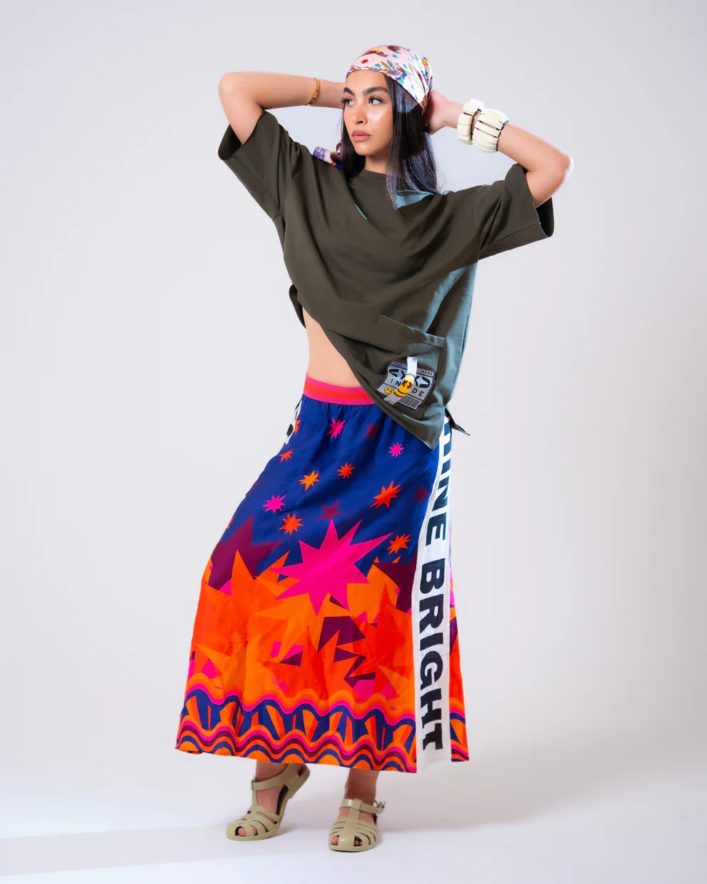 Woman wearing a colorful skirt with star patterns and text on a white background