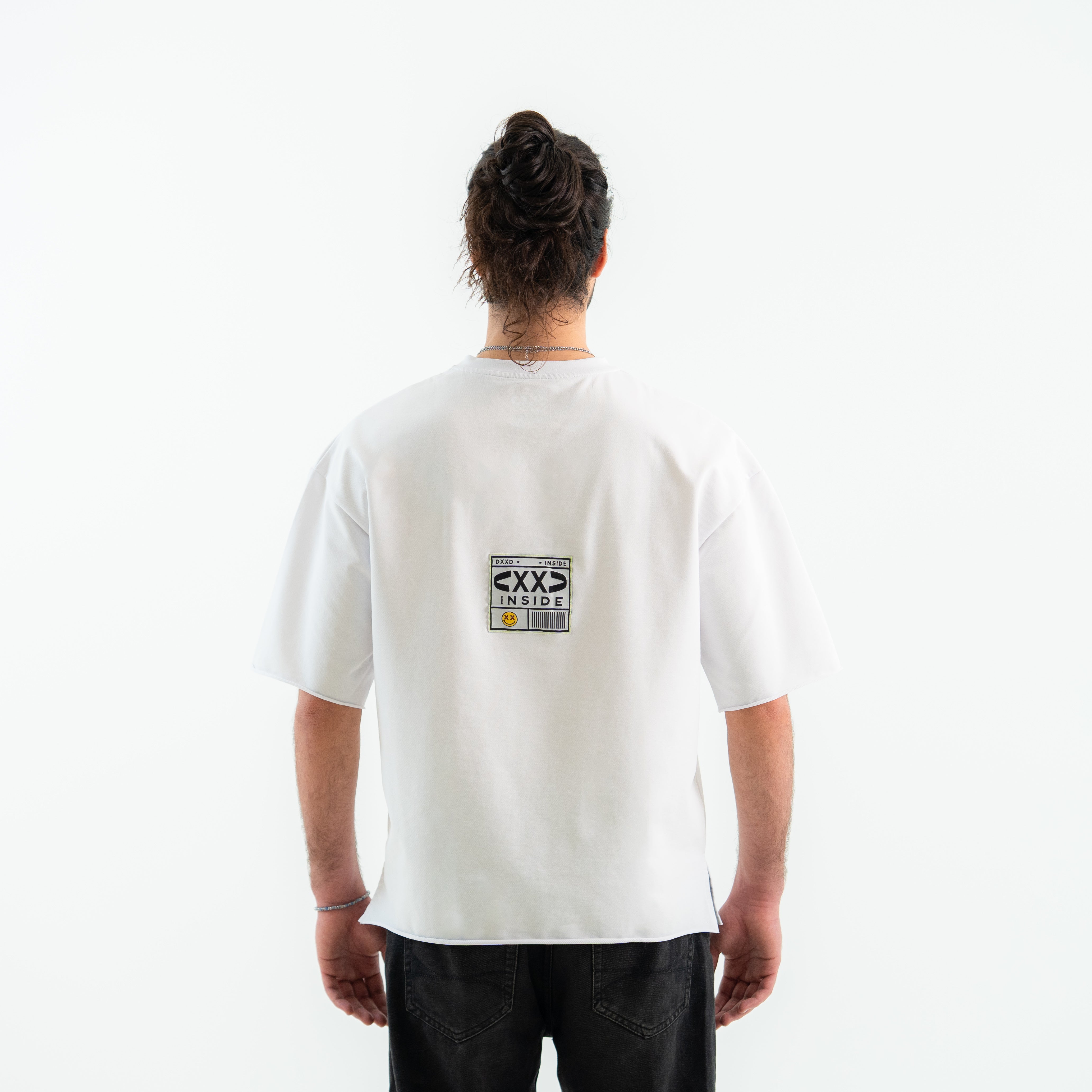 Person wearing a white t-shirt with a logo on the back against a white background