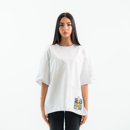 Person wearing a white oversized t-shirt with graphic designs on a plain background