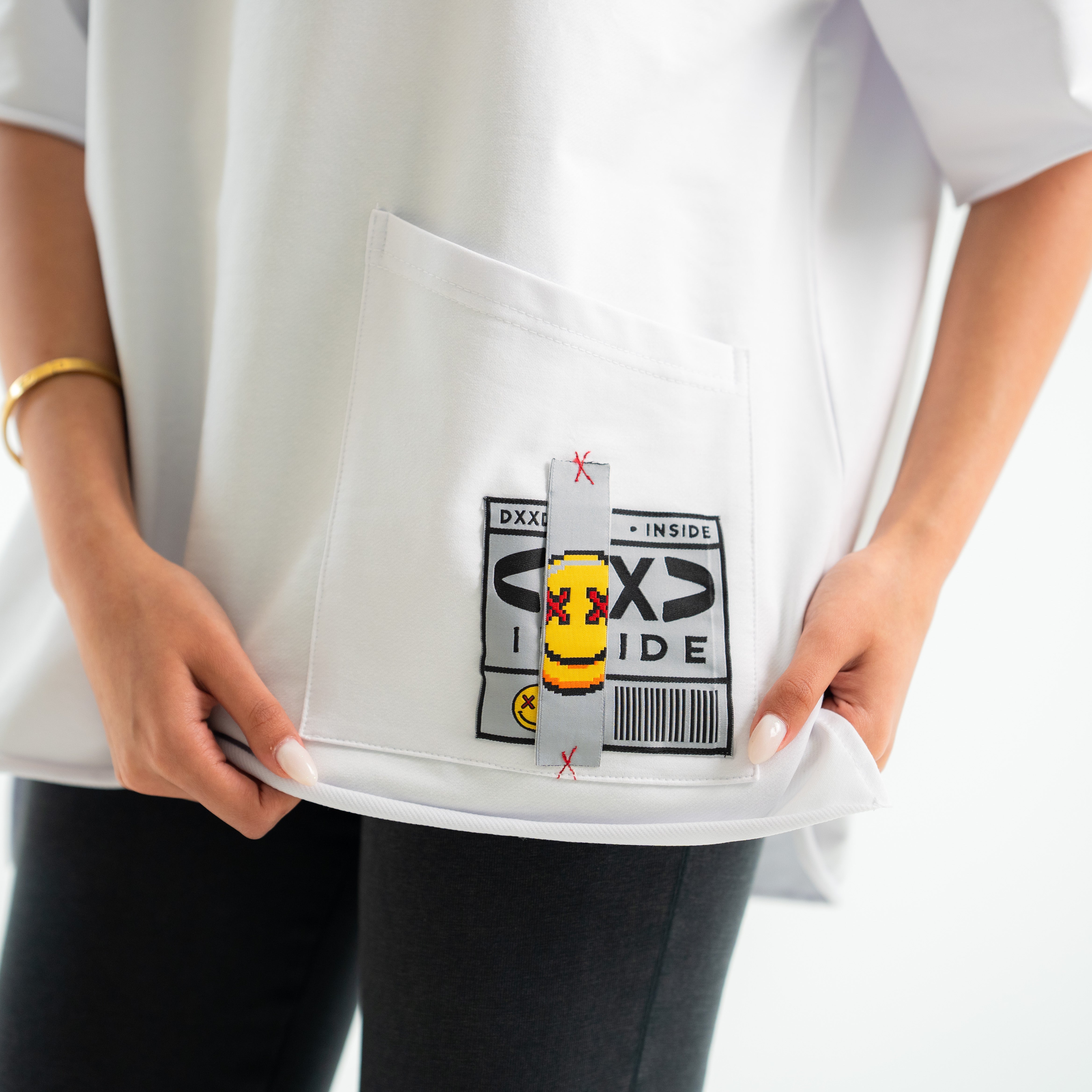 Person holding a white container with a small toy figure inside, featuring a visible brand logo.