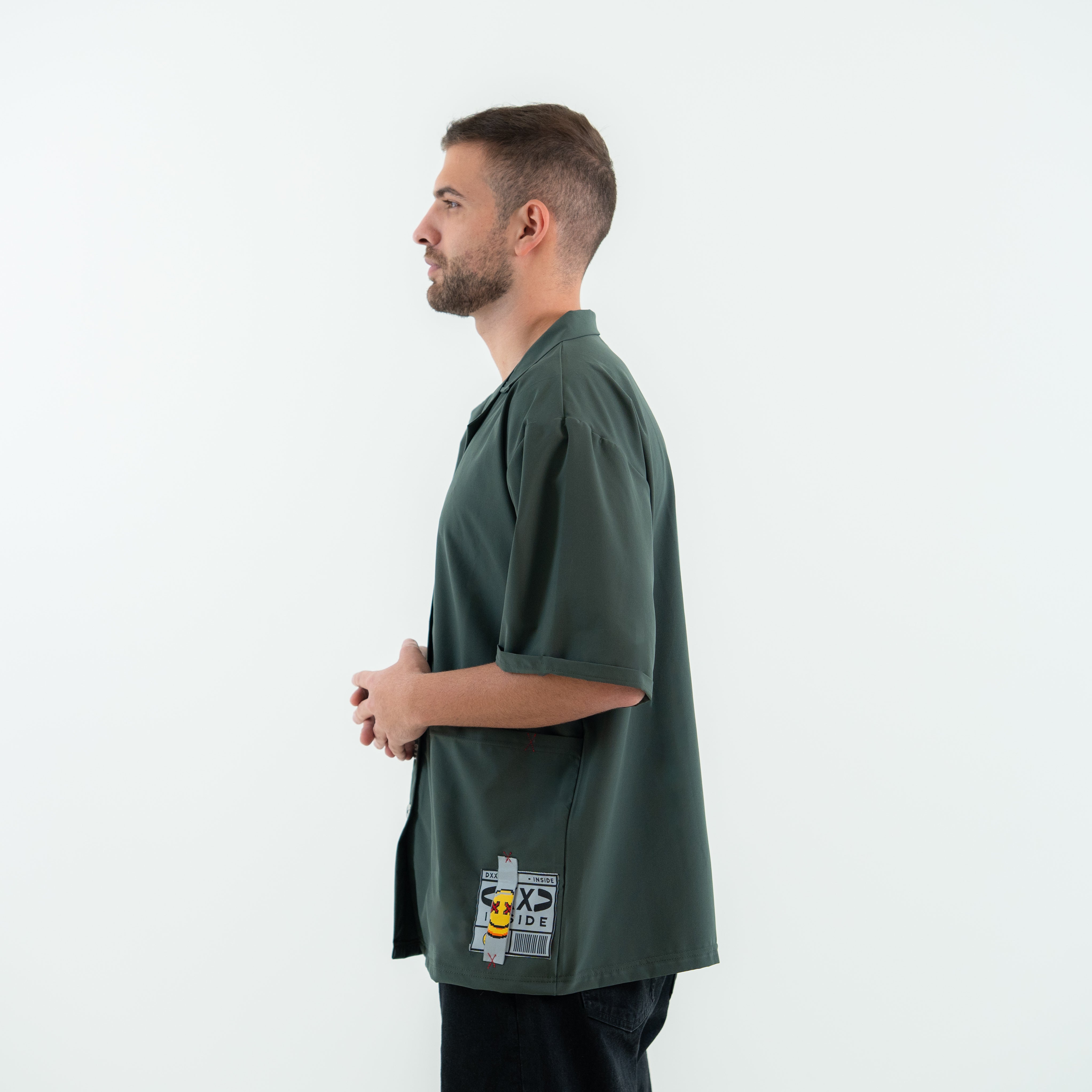 Man wearing a green t-shirt with a graphic design on a white background