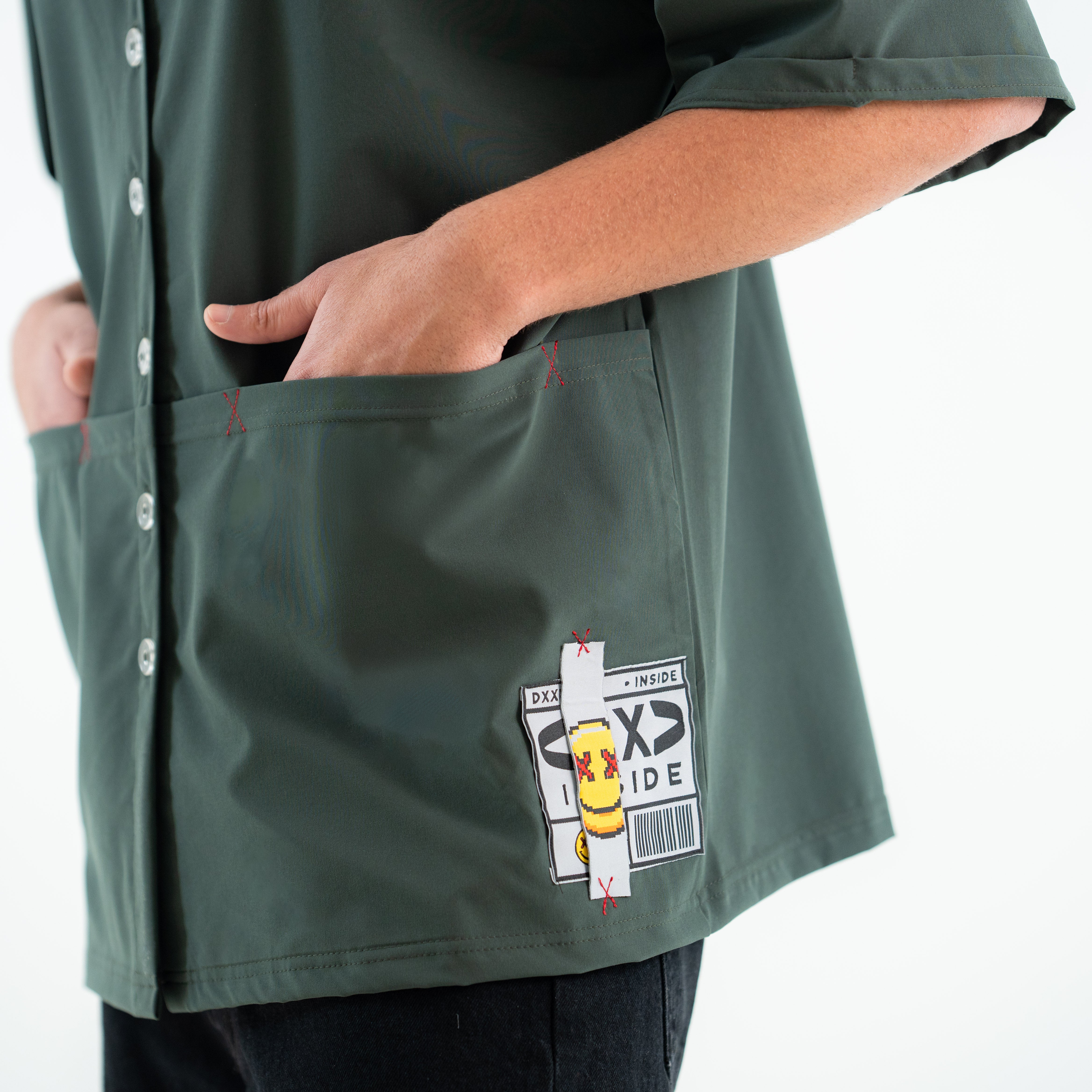 Green shirt with a patch on the pocket against a white background