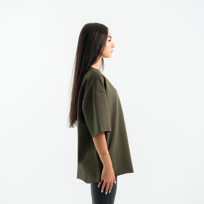 Woman wearing an olive green oversized shirt on a white background