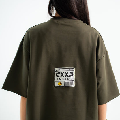 Person wearing a green t-shirt with a graphic design on the back against a white background