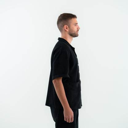 Man wearing a black outfit against a white background