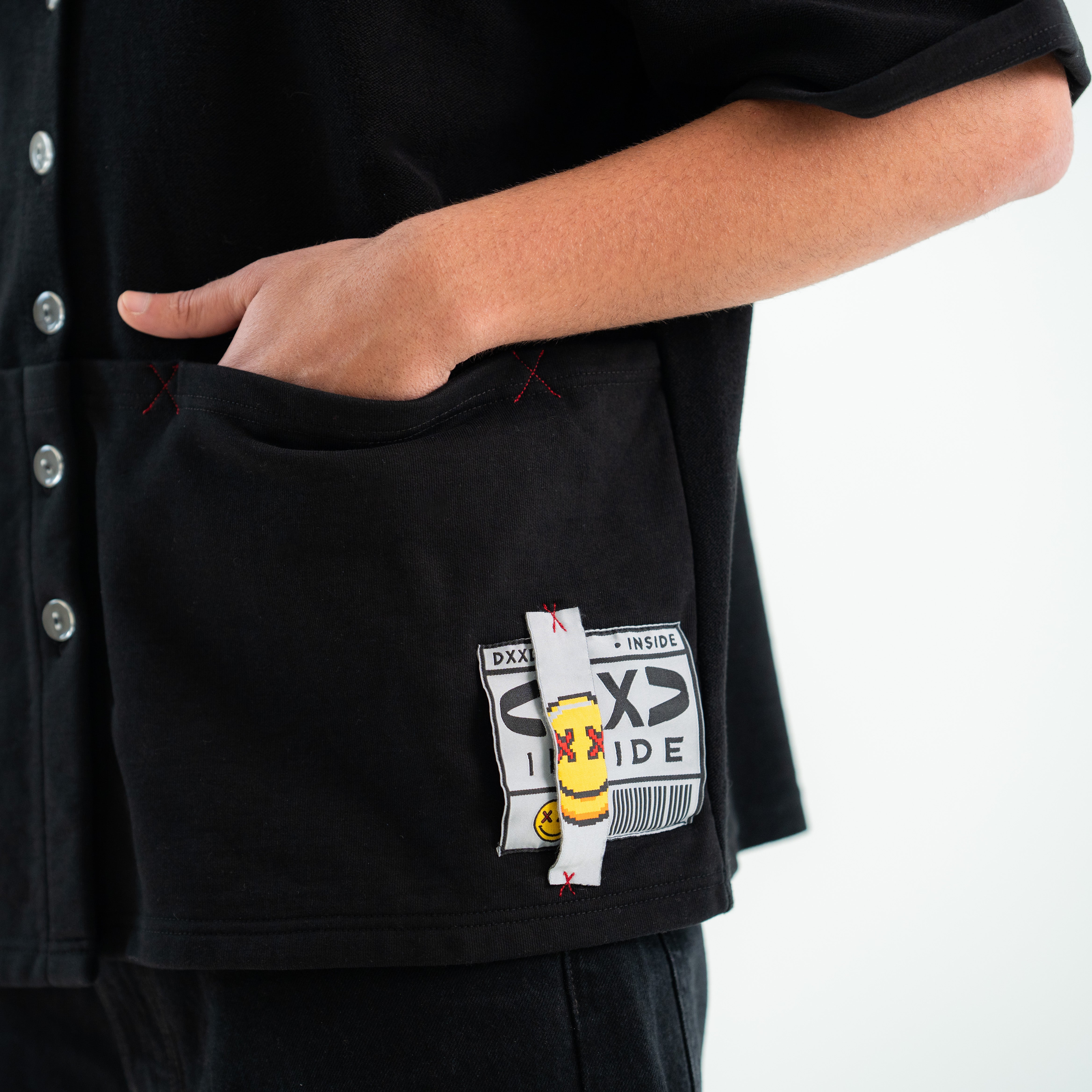Black shirt with a cartoon character patch on a white background