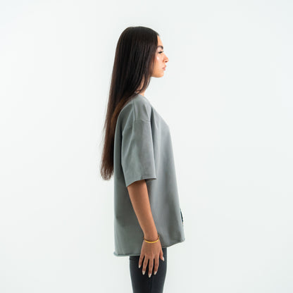 Woman wearing a gray oversized t-shirt on a white background