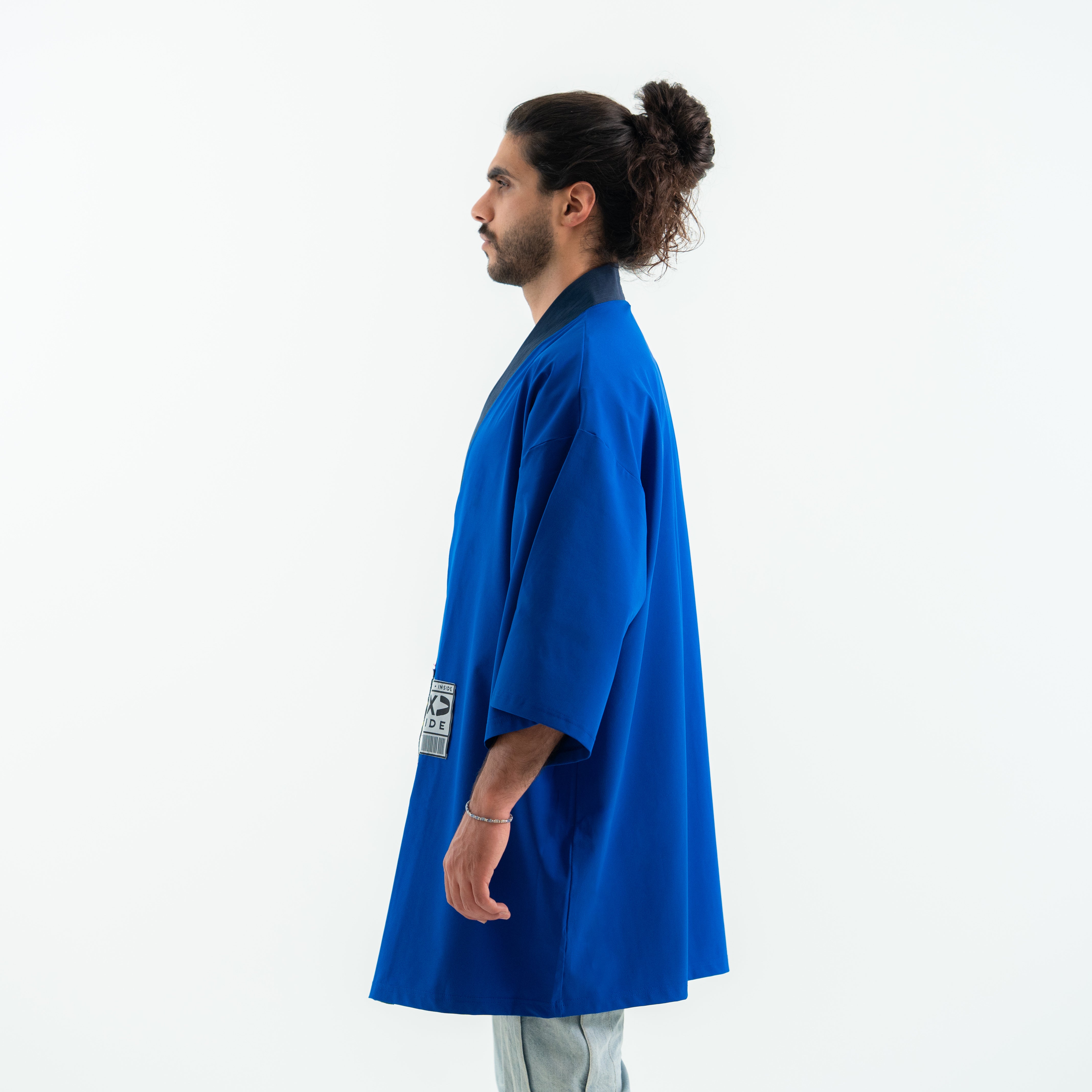 Man wearing a blue kimono-style garment on a white background