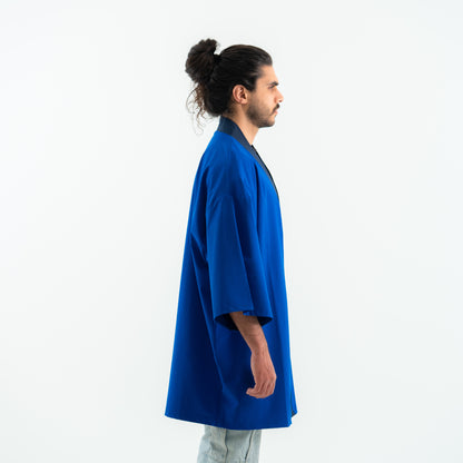 Person wearing a blue kimono-style garment on a white background