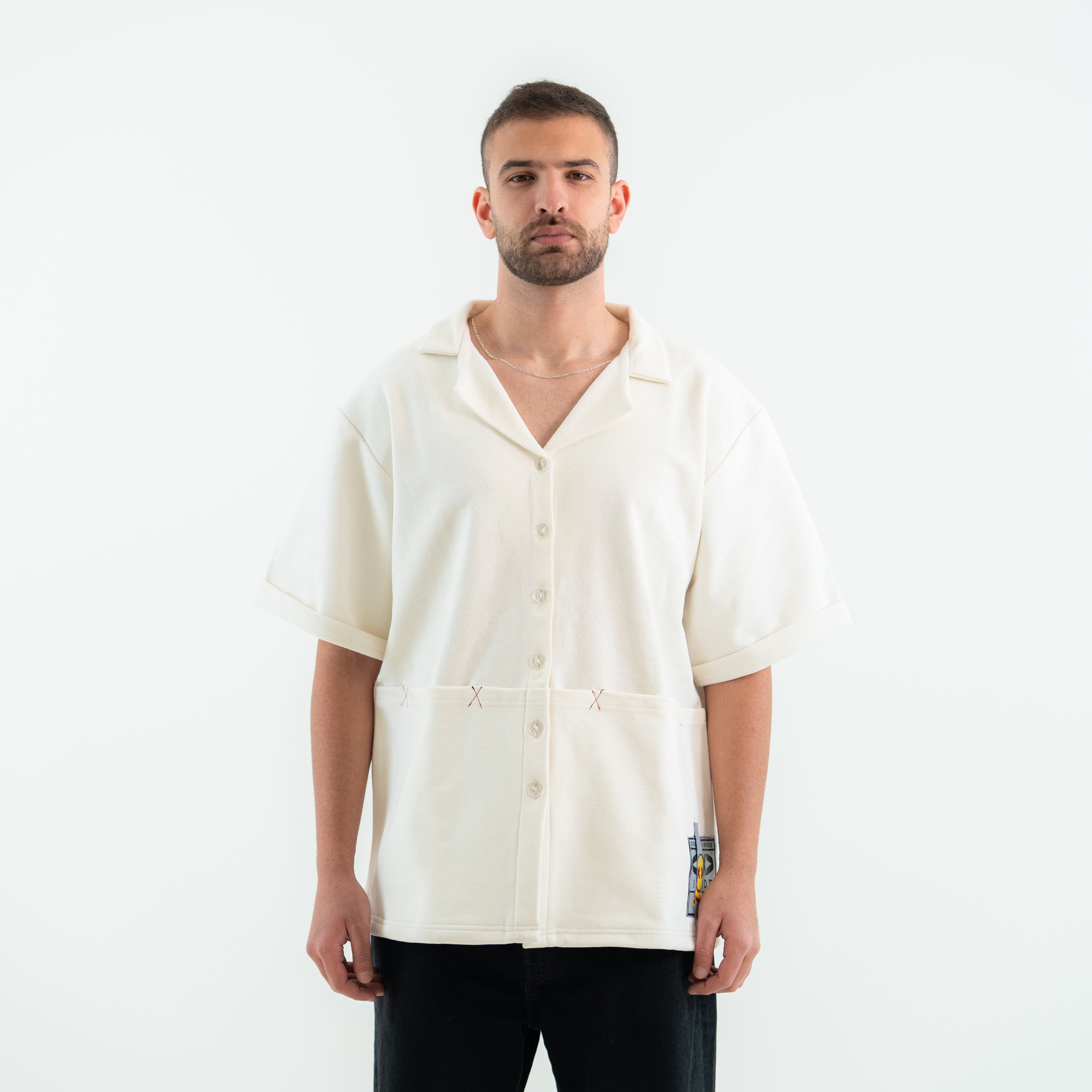 Man wearing a cream-colored shirt with short sleeves on a white background