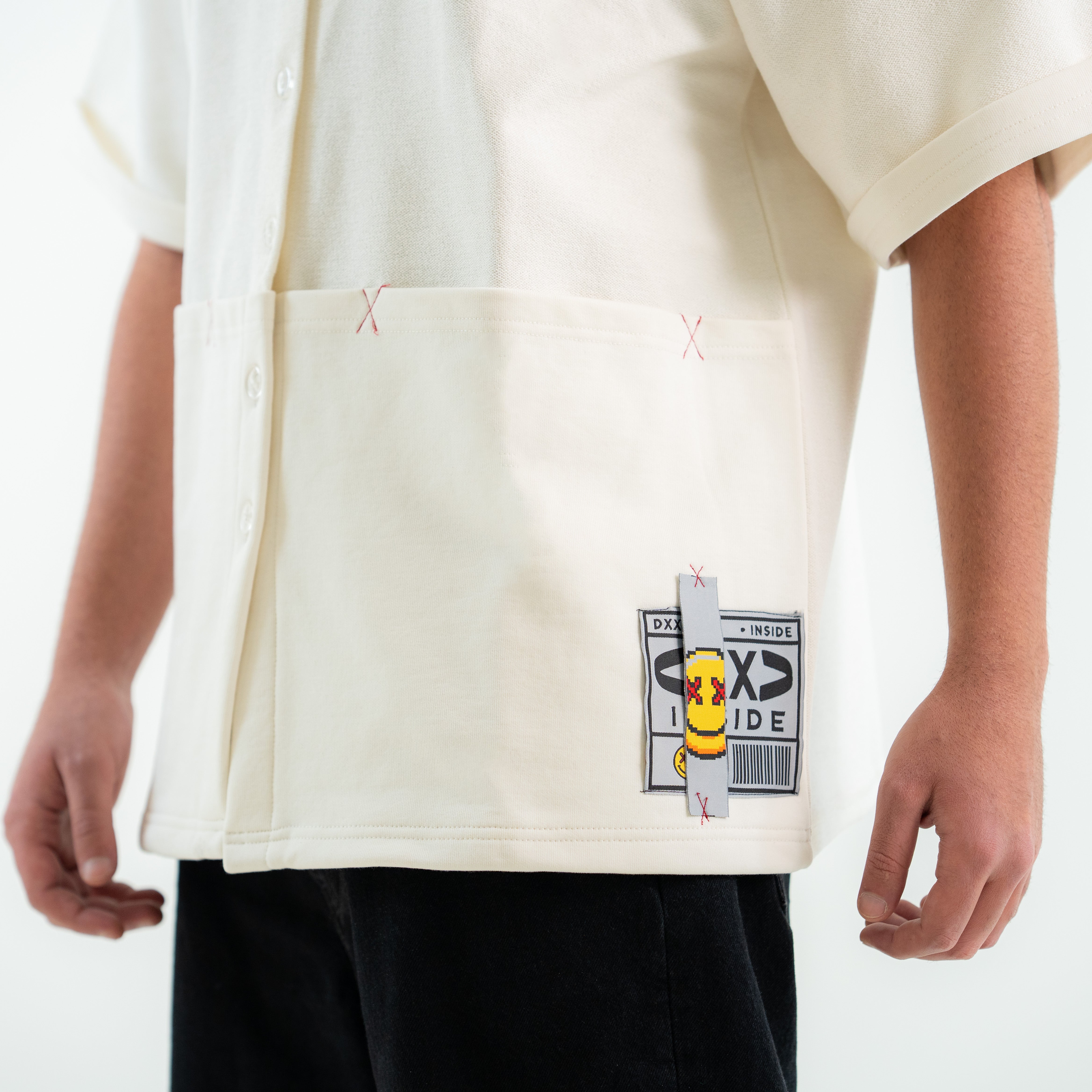 Person wearing a white t-shirt with a unique design and text on a plain background