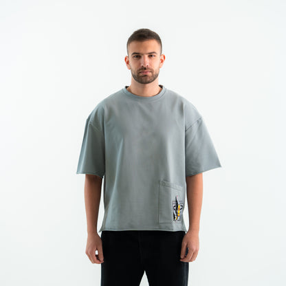 Man wearing a gray t-shirt with a pocket on a white background