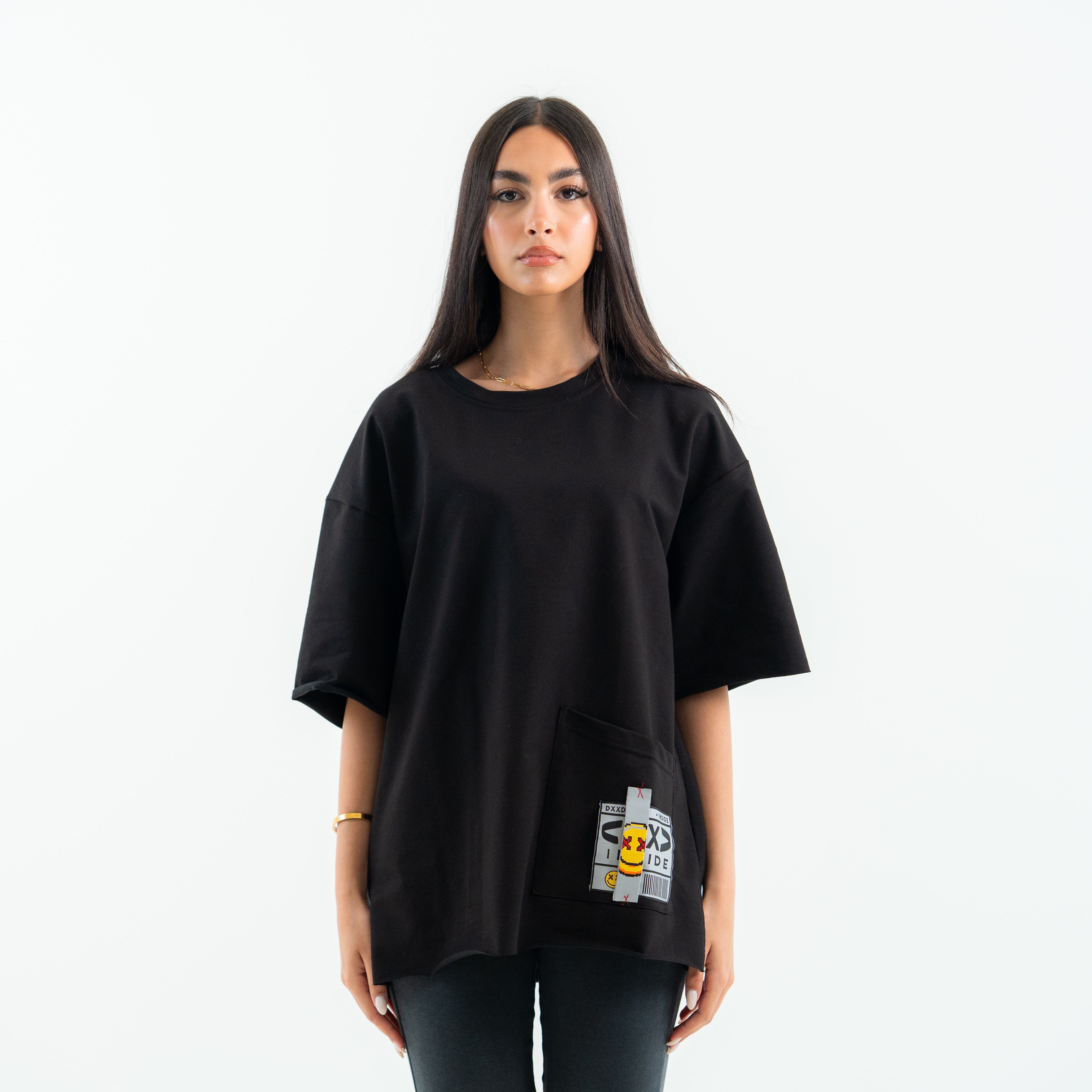 Person wearing a black oversized t-shirt with a graphic design on a white background