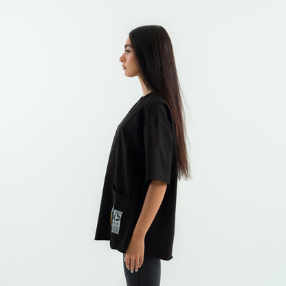 Woman wearing a black oversized t-shirt with a small logo on a white background