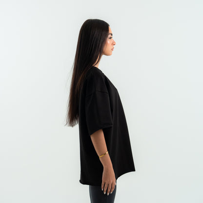 Woman wearing a black oversized shirt against a white background